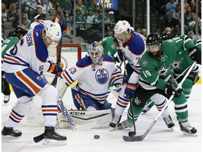 Edmonton Oilers' Adam Larsson (6) and Oscar Klefbom (77) of Sweden help Cam Talbot (33) clear a puck away from the net under pressure from Dallas Stars' Patrick Eaves (18) in the first period of an NHL hockey game, Saturday, Nov. 19, 2016, in Dallas.