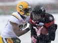 Ottawa RedBlacks' Kienan Lafrance (27) takes a tackle from Edmonton Eskimos' Marcell Young (23) during first half CFL eastern final action, in Ottawa on Sunday, November 20, 2016.