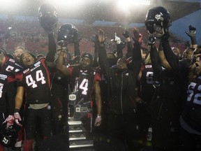 Ottawa Redblacks players celebrate in front of the Eastern Division trophy after defeating the Edmonton Eskimos 35-23 following the CFL Eastern Final, in Ottawa on Sunday, November 20, 2016.