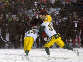 Ottawa Redblacks running back Kienan Lafrance jumps over Edmonton Eskimos defensive back Kenny Ladler, right, and his teammate Neil King during second half CFL Eastern Final action, in Ottawa on Sunday, November 20, 2016.