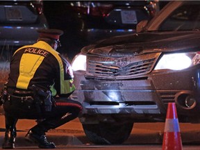 Calgary police investigate a car involved in a collision with a pedestrian on Nov. 2, 2016. Transportation officials say the return to standard time makes it more difficult for pedestrians to be seen in the evening.