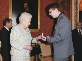 Queen Elizabeth II awards Tyler Bailer, 17 from Wetaskiwin, with the Russell Medal during a reception held for the Royal Life Saving Society at Buckingham Palace on November 22, 2016 in London, United Kingdom.