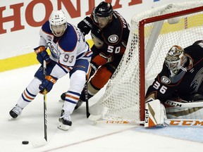 Edmonton Oilers center Ryan Nugent-Hopkins (93) controls the puck with Anaheim Ducks center Antoine Vermette (50) trailing and goalie John Gibson (36) watching during the third period of an NHL hockey game in Anaheim, Calif., Tuesday, Nov. 15, 2016. The Ducks won 4-1.