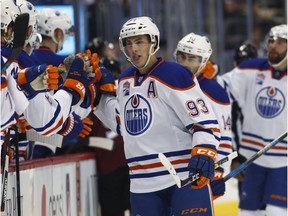 Edmonton Oilers center Ryan Nugent-Hopkins is congratulated as he passes the team box after scoring an unassisted goal against the Colorado Avalanche in the first period of an NHL hockey game, Wednesday, Nov. 23, 2016, in Denver.