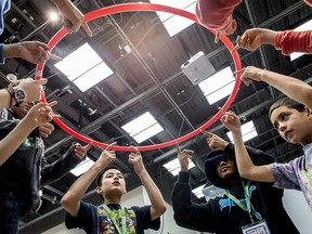 Youngsters involved with the FIRST Lego League gathered at the University of Alberta on Nov. 26, 2017, work on a team-building exercise where theys raise and lower a hula-hoop in unison with just their fingertips.