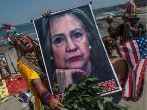 Shamans perform a ritual of predictions for the upcoming U.S. election with posters of presidential candidates Donald Trump and Hilary Clinton at the Agua Dulce beach in Lima on November 7, 2016.