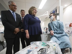 Dr. Mintoo Basahti, Dr. Paul Major and Minister of Health Sarah Hoffman (from left to right) chats with third year dentistry student Benjamin Hughes at the University of Alberta School of Dentistry on Dec. 8, 2016. The provincial government has announced that it is going to create a public dental fee guide.