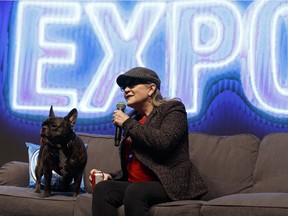 Carrie Fisher speaks on stage with her dog Gary during the Edmonton Comic & Entertainment Expo at the Edmonton Expo Centre on Saturday, September 24, 2016.