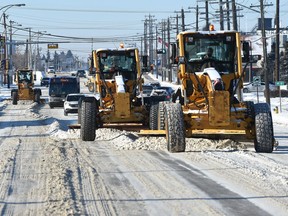 A team of graders clearing snow along 52 Avenue near 97 Street in Edmonton, Monday, December 26, 2016.