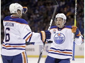 Edmonton Oilers forward Tyler Pitlick, right, is congratulated by Adam Larsson, of Sweden, after scoring during the first period of an NHL hockey game against the St. Louis Blues Monday, Dec. 19, 2016, in St. Louis. Pitlick sustained a knee injury in the game and is out for the season.