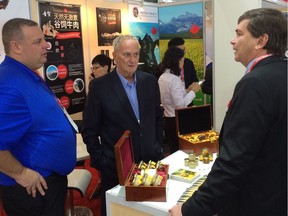 Agriculture and Forestry Minister Oneil Carlier, (right) speaks with marketers representing Wolfe's Honey, a company based in Falher, Alta. Wolfe's Honey was one of the many Alberta products featured at a recent trade show in China which Carlier attended.