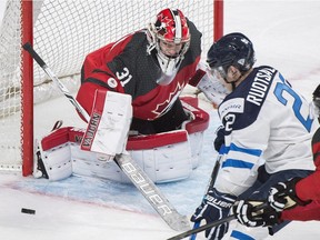 Finland's Arttu Ruotsalainen (22) moves in on Canada goaltender Carter Hart as Canada's Noah Juulsen defends during second period pre-tournament exhibition hockey action in Montreal, Monday, December 19, 2016. IIHF World Junior Championship starts on Monday, Dec. 26, 2016.