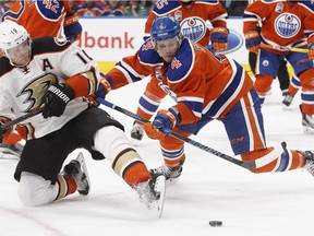 Anaheim Ducks' Corey Perry (10) and Edmonton Oilers' Kris Russell (4) battle in front of the net during third period NHL action in Edmonton, Alta., on Saturday, December 3, 2016.