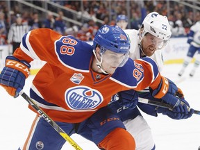 Vancouver Canucks' Daniel Sedin (22) and Edmonton Oilers' Brandon Davidson (88) battle for the puck during first period NHL action in Edmonton, Alta., on Saturday December 31, 2016.