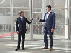 Edmonton Oilers owner Daryl Katz, left, and Edmonton Mayor Don Iveson prepare to pull the banner down during the opening ceremony at Rogers Place, the new home of the Edmonton Oilers, in Edmonton, on Sept. 8, 2016.