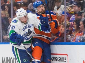 Edmonton Oilers Jordan Eberle (14) gets checked by Vancouver Canucks Sven Baertschi (47) during first period NHL action at Rogers Place, in Edmonton December 31, 2016.