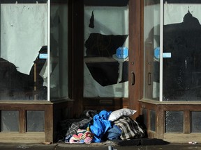 A homeless man sleeps in a doorway on Jasper Avenue east of 97 Street in Edmonton in a 2014 file photo.