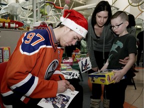 Edmonton Oilers captain Connor McDavid autographs a photo for Stollery Children's Hospital patient Luca Flynn, 8, and his mother Jennifer. McDavid and other members of the team made their annual visit to the hospital on December 15, 2016.