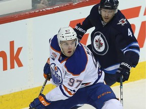 Edmonton Oilers center Connor McDavid (l) breaks away from Winnipeg Jets defenceman Paul Postma during NHL hockey in Winnipeg, Man. Thursday December 01, 2016. Brian Donogh/Winnipeg Sun/Postmedia Network