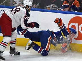 Edmonton Oilers Connor McDavid (97) gets pushed to the ice by Columbus Blue Jackets David Savard (58) during the second period of NHL action at Rogers Place in Edmonton, Wednesday, December 13, 2016.