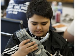 Khalil Al-Sabbag checks out a demonstration prosthetic hand during the Edmonton 2016 Hand-a-Thon at Queen Elizabeth High School in Edmonton, Alberta on Friday, December 16, 2016. The event saw students assemble 3D printed prosthetic hands. Ian Kucerak / Postmedia