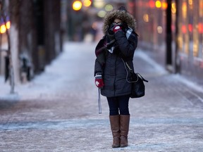 A pedestrian waits for a light while make their way through the bitter cold along Jasper Avenue near 102 Street in a 2016 file photo.