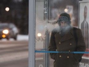 Farzan Gholamreza's breath freezes on a bus shelter as he waits for his bus at 113 Street and 72 Avenue on a cold afternoon in Edmonton, Alberta on Tuesday, December 6, 2016.