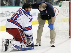 A trainer, right, checks on New York Rangers goalie Henrik Lundqvist (30) after a hit by Dallas Stars forward Cody Eakin during the first period of an NHL hockey game, Thursday, Dec. 15, 2016, in Dallas.