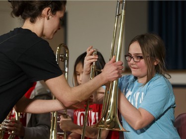 Krystal, a music student in the Edmonton Symphony Orchestra and the Winspear Centre for Music's YONA-Sistema music program, exchanges her plastic practice instrument for a real trombone during a ceremony at St. Alphonsus Catholic School in Edmonton, Alberta on Wednesday, December 7, 2016.