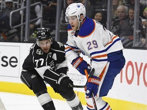 Edmonton Oilers center Leon Draisaitl, right, of Germany, tries to pass the puck while under pressure from Los Angeles Kings center Jeff Carter during the first period of an NHL hockey game, Thursday, Nov. 17, 2016, in Los Angeles.