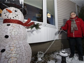 Marion Broverman shows the chain that now secures a snowman decoration, a replacement for a larger snowman stolen on Dec. 8 that was the centrepiece to her Christmas lights in Edmonton, Alberta on Friday, Dec. 9, 2016.