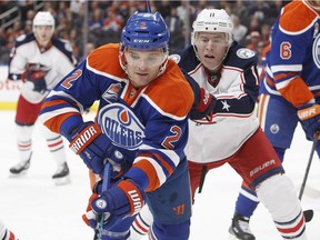 Columbus Blue Jackets' Matt Calvert (11) and Edmonton Oilers' Andrej Sekera (2) battle for the puck during first period NHL action in Edmonton, Alta., on Tuesday December 13, 2016.