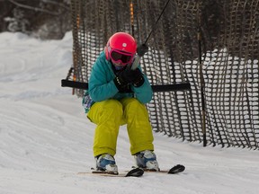 Mila Tulik, 9, rides the T-bar to the top of the hill at the Edmonton Ski Club on Tuesday, Dec. 27, 2016, in Edmonton.
