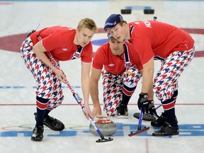 Norway's Thomas Ulsrud (C) throws the stone while his teammates Haavard Vad Petersson (L) and John Christoffer Svae (R) sweep during the 2014 Sochi winter olympics men's curling round robin session 4 match against Switzerland at the Ice Cube curling centre in Sochi on February 12, 2014.