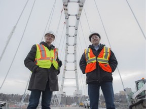 Lead designer Jim Montgomery (left) of Dialogue Designs and construction project manager Ryan Teplitsky, with the City of Edmonton, stand on the new Walterdale Bridge, slated to open two years late.