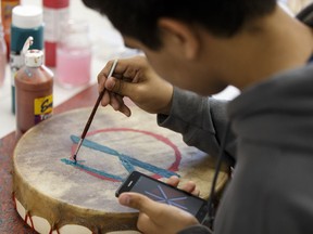 Gunnei Nelson, 13, paints his drum during class at Oskayak Police Academy held at Amiskwaciy Academy in Edmonton, on Thursday, July 14, 2016.
