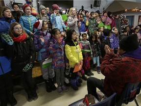 Students from George H. Luck School sing Christmas carols for patrons of the Boyle Street Community Services after delivering hundreds of backpacks to the centre on December 19, 2016. The backpacks will be distributed to the homeless and people in need.