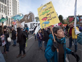 A woman holds a sign during a protest and march against the Kinder Morgan Trans Mountain Pipeline expansion, in Vancouver on Nov. 19, 2016.