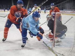 Ryan Nugent-Hopkins is pushed from behind by Brandon Davidson as the Edmonton Oilers practice at Rogers Place leading up to a New Year's Eve game against the Vancouver Canucks. (Shaughn Butts)