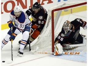 Edmonton Oilers center Ryan Nugent-Hopkins (93) controls the puck with Anaheim Ducks center Antoine Vermette (50) trailing and goalie John Gibson (36) watching during the third period of an NHL hockey game in Anaheim, Calif., Tuesday, Nov. 15, 2016. The Ducks won 4-1.