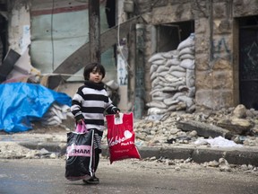 A Syrian boy is seen among other civilains leaving a rebel-held area of Aleppo towards the government-held side on December 13, 2016 during an operation by Syrian government forces to retake the embattled city. UN chief Ban Ki-moon expressed alarm over reports of atrocities against civilians Monday, as the battle for Aleppo entered its final phase with Syrian government forces on the verge of retaking rebel-held areas of the city.