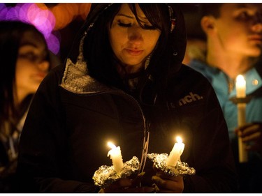 A woman holds two candles as she takes part in a candlelight vigil for Radek MacDougall and Ryder MacDougall, in Spruce Grove Thursday Dec. 22, 2016. The two boys were were found dead in their Spruce Grove home on Monday Dec. 19, 2016. Photo by David Bloom