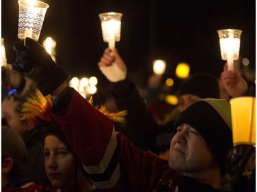 A young hockey player cries as he takes part in a candlelight vigil for Radek MacDougall and Ryder MacDougall, in Whitecourt on Tuesday Dec. 20, 2016. The two boys were were found dead in their Spruce Grove home on Monday Dec. 19, 2016. Photo by David Bloom