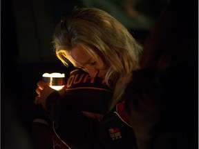 Tracy Stark hugs a young boy as she takes part in the candlelight vigil for her sons Radek MacDougall and Ryder MacDougall, in Whitecourt on Tuesday Dec. 20, 2016. The two boys were were found dead in their Spruce Grove home on Monday Dec. 19, 2016.
