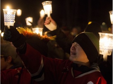 A young hockey player cries as he takes part in a candlelight vigil for Radek MacDougall and Ryder MacDougall, in Whitecourt on Tuesday Dec. 20, 2016. The two boys were were found dead in their Spruce Grove home on Monday Dec. 19, 2016.