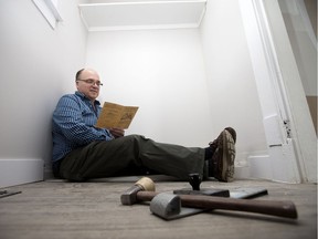 Roy Phillips sits in the former pantry of his mother Maureen Phillips' family home and reads her Grade 8 report card, in Edmonton Monday Jan. 16, 2017.