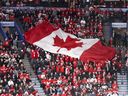 Un drapeau canadien est passé autour du Centre Bell lors du match pour la médaille d'or d'Équipe Canada contre les États-Unis au tournoi de hockey du Championnat mondial junior 2017 à Montréal.  Le tournoi 2021-2022 reprend à Edmonton en août sous un nuage de controverse sur le traitement par Hockey Canada des allégations d'agression sexuelle.