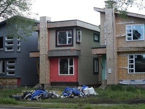 Several narrow homes under construction along 102 Avenue.