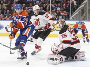 New Jersey Devils goalie Cory Schneider makes the save as Edmonton Oilers' Jordan Eberle and Devils' Ben Lovejoy look for the rebound in Edmonton on Jan. 12, 2017. (The Canadian Press)