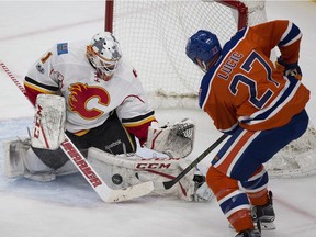 Edmonton Oilers Milan Lucic, right, can't get the puck past Calgary Flames goalie Brian Elliott during first period NHL action on January 14, 2017 in Edmonton.